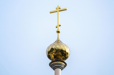 Fototapeta na wymiar christian church with a dome and a cross against a blue sky