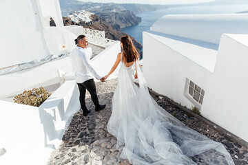 Wedding on Santorini island in Greece, beautiful couple, bride in a white wedding dress. White...