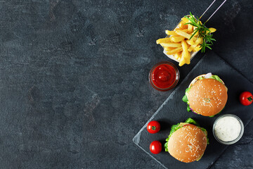 Fast food burger menu, french fries and ketchup sauce on black background.