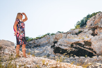 the woman walks alone through the mountains and observes the landscape