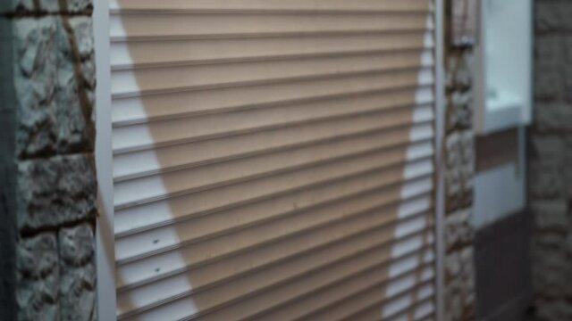 Roller shutters at closed shop door on a city street in the evening, urban streets at night.