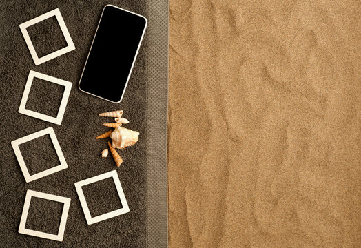 Concept photo beach memories collage photo frames mockup on gray towel, smart phone with black screen, shells. fine beach sand. Top view, space for text
