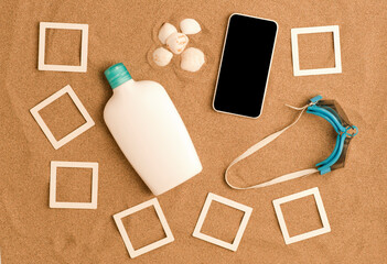 beach concept, mockup photo collage, smartphone, sun cream bottle, swimming goggles and white shells, beach sand background