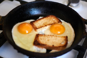 Two fried eggs with toast in a pan.