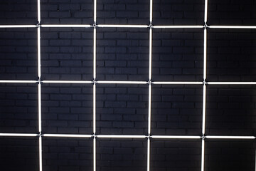 Neon grid on a dark brick wall