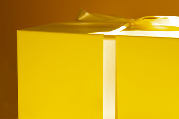 Empty mockup paper yellow box with ribbon on sun shine.- Image