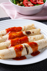 .Pancakes with meat, in tomato sauce and cheese.