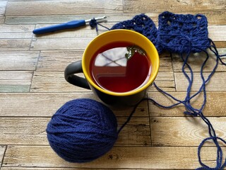 cup of tea and crochet on a wooden background