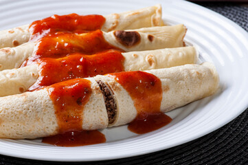.Pancakes with meat, in tomato sauce and cheese.