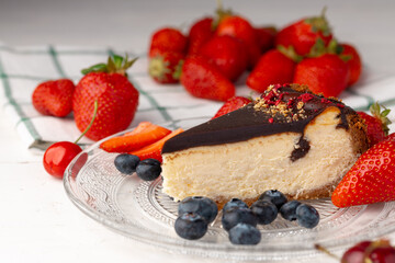 Piece of cheesecake with chocolate top and berries