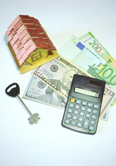 Home mortgage composition with calculator, house model, key and paper currencies (Euros, dollars, rubles) against white background. Real estate assessments, finances, banking or home credits