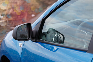 Obraz premium Side rearview mirror on a modern car, view of the car interior through a closed glass