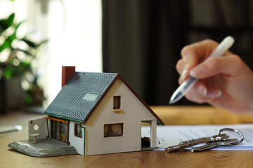 A person signing a contract for buying a house