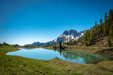 Fototapeta na wymiar Calm lake in a sunny day in the beautiful Carnic Alps, Friuli-Venezia Giulia, Italy
