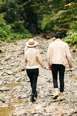 Young couple at the Carpathian - Happy tourists visiting mountains. Lovestory. Tourists in hats. Military fashion.