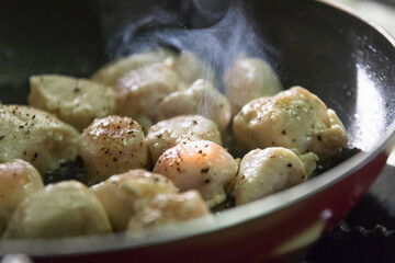 Diced chicken breast pan frying with black pepper and salt; healthy meal. 