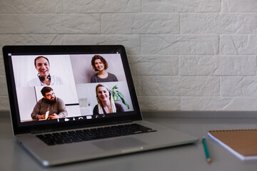 Business Person Videoconferencing With Colleagues On Laptop