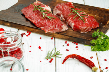 Barbecue veal steaks with rosemary on wooden board
