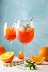 Composition with aperol spritz cocktail against blue background