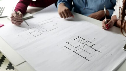 Group of business people discussing blueprint, meeting and talking at table and working on building floor plan. Cropped shot, high angle. Architecture or paperwork concept