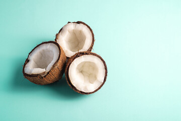 Coconut fruits on blue vibrant plain background, abstract food tropical concept, angle view copy space