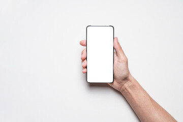 Smartphone mockup. Businessman holding phone with blank white screen on gray background. Template...