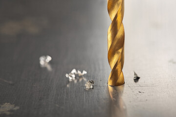 metal drill bit make holes in steel billet on industrial drilling machine with shavings. Metal work...
