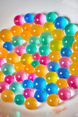 Plate with many transparent colorful jelly balls. Sweet tasty dessert. Food and drink backgrounds