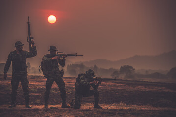 Team special forces. soldier assault rifle with silencer.Silhouette action soldiers hold...