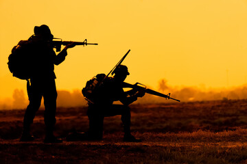 Fototapeta na wymiar Team special forces. soldier assault rifle with silencer.Silhouette action soldiers hold weapons.military and danger concept.