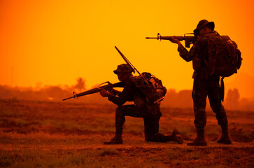 Team special forces. soldier assault rifle with silencer.Silhouette action soldiers hold...