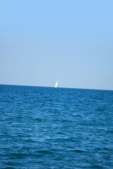 Fototapeta premium Sailboat on ocean or lake with deep blue waves 