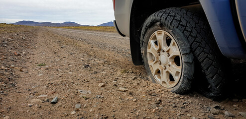 Fototapeta na wymiar Burst tyre on dirt road in Patagonia