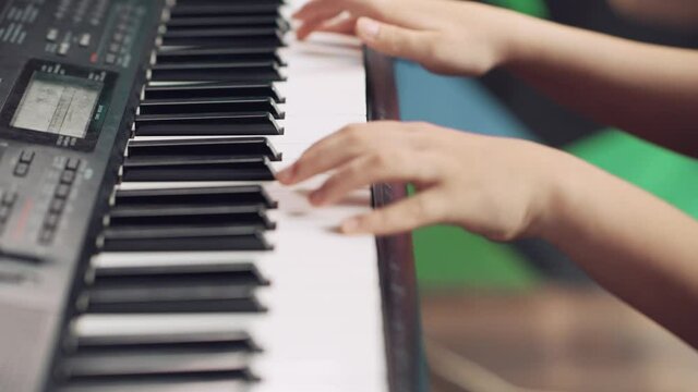 Close-up of children's hands on the keys of a piano, synthesizer.