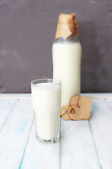 Fresh milk in a glass and a bottle on a wooden background. Dairy products as a source of calcium. Healthy eating