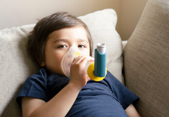 Poor boy have a problem with chest coughing holding inhaler mask, Child using the volumtic for...