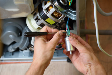 handyman repairs dishwasher with screwdriver