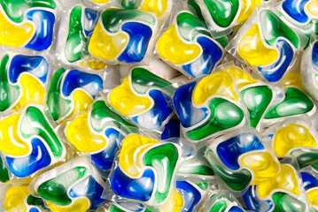Liquid dishwashers capsules, background of all-in-one capsules with laundry detergent and...