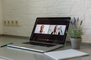 Business Person Videoconferencing With Colleagues On Laptop