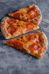 Pepperoni pizza slice on black slate background. Slices of pepperoni pizza, top view copy spac