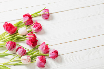 red tulips on white wooden background