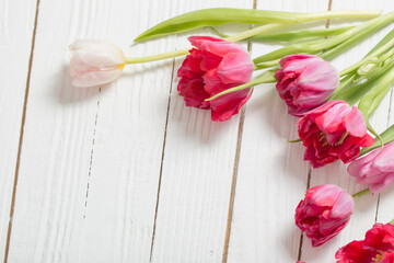 Fototapeta na wymiar beautiful tulips on white wooden background