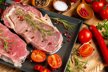 Two raw beef steaks on dark wooden table