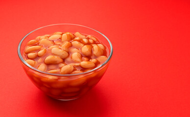 Baked beans in tomato sauce isolated on red background