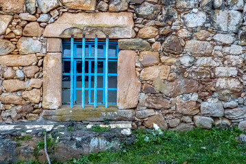 Fototapeta na wymiar Old stone wall with iron railing window, Caraca Sanctuary, city of Catas alta, state of Minas Gerais, Brazil