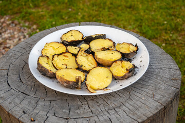 Baked potatoes in the garden bonfire served on a plate