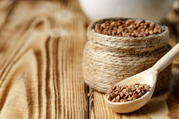 Wooden spoon with uncooked buckwheat close up