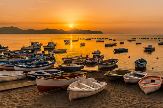 The beach and fishing boats at Aspra Sicily as the sun goes down on a summer's evening