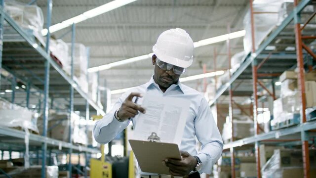 Ecommerce manager looks over inventory and logistics a warehouse facility. Back to work and business is booming. Shot in 4k 