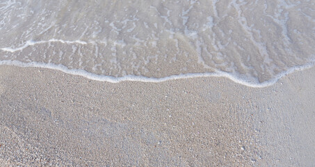 Close-up of white sand, washed by soft sea waves